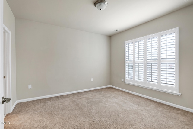 spare room featuring baseboards and carpet