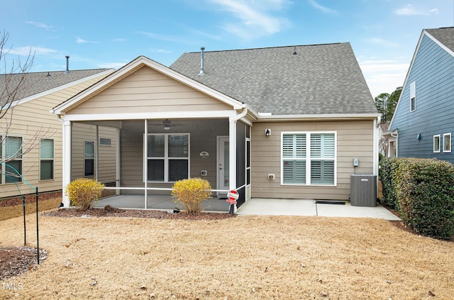 back of property with a patio, central AC unit, a sunroom, and a shingled roof