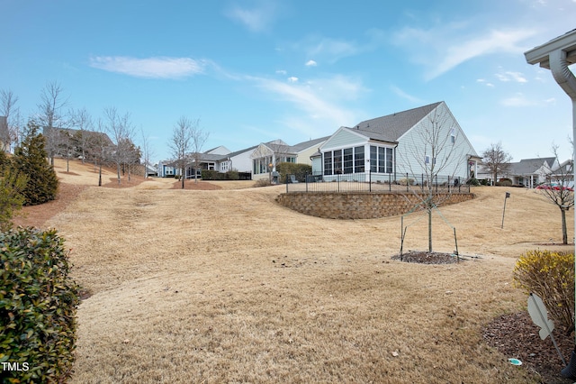 view of yard featuring a residential view and a sunroom