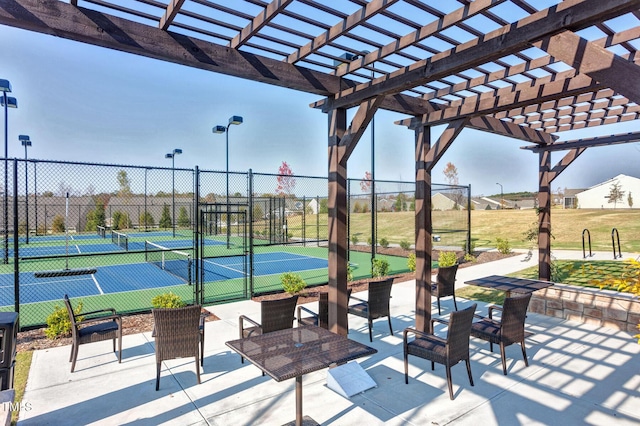 view of sport court with a gate, a pergola, and fence