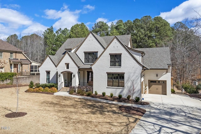 view of front of property with brick siding, concrete driveway, fence, and a shingled roof