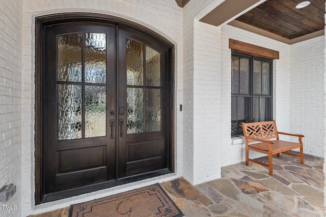 view of exterior entry with french doors and brick siding