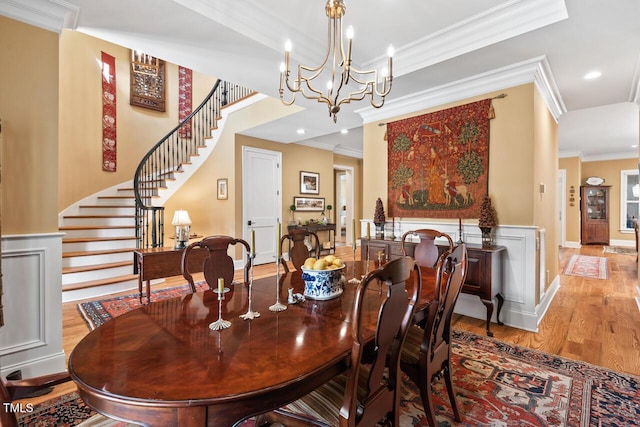 dining space featuring ornamental molding, wood finished floors, recessed lighting, baseboards, and stairs