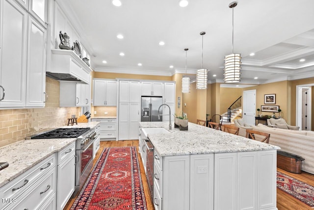 kitchen with light wood-style floors, appliances with stainless steel finishes, white cabinets, and crown molding