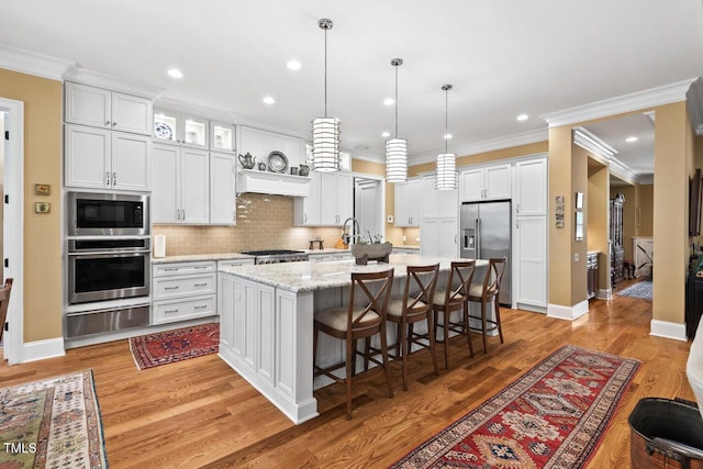 kitchen with decorative backsplash, white cabinets, stainless steel appliances, and a warming drawer