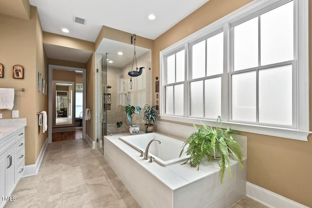 bathroom featuring visible vents, a stall shower, vanity, and baseboards