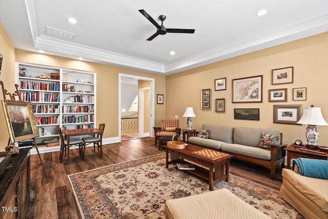 living area featuring a raised ceiling, recessed lighting, and wood finished floors