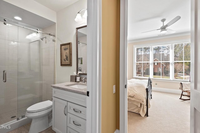 bathroom featuring toilet, a stall shower, vanity, and a ceiling fan