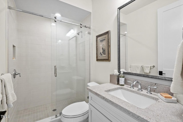 full bathroom with vanity, toilet, and a stall shower