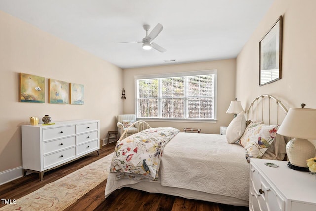 bedroom with dark wood-type flooring, a ceiling fan, and baseboards