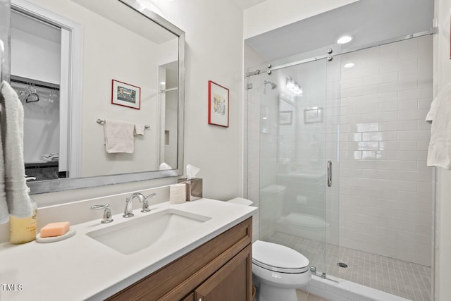 bathroom featuring a stall shower, toilet, and vanity