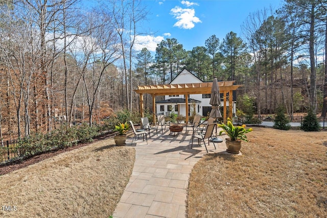 view of yard featuring a patio, fence, a fire pit, and a pergola