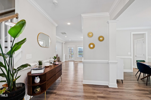 hallway with ornamental molding, baseboards, ornate columns, and wood finished floors