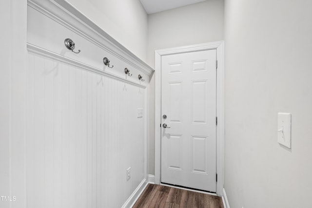 doorway featuring baseboards and dark wood finished floors