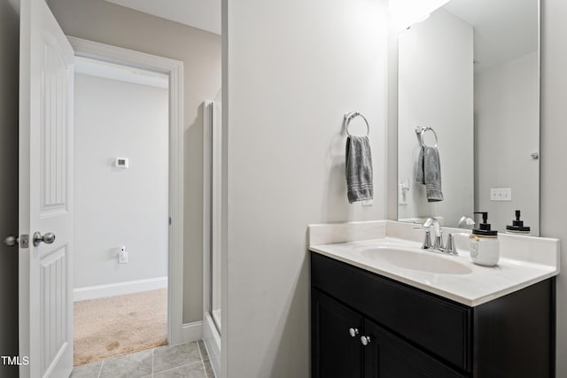 full bathroom with tile patterned floors, a stall shower, vanity, and baseboards