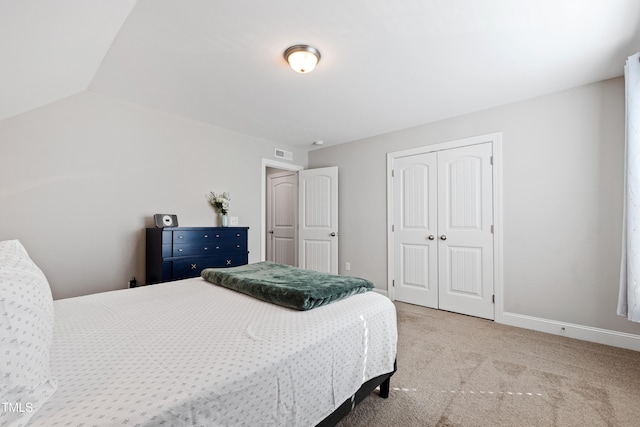 bedroom with visible vents, baseboards, vaulted ceiling, carpet flooring, and a closet