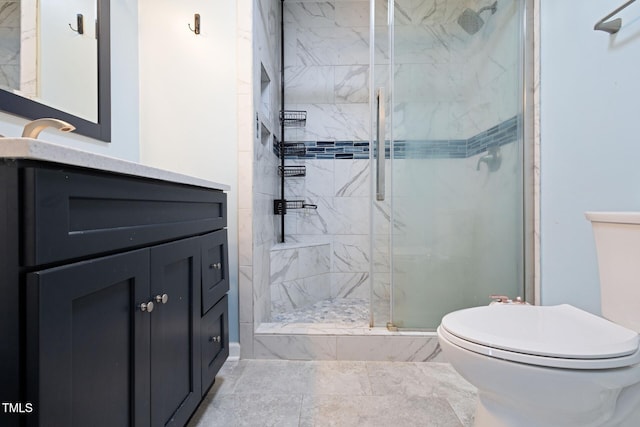 full bathroom featuring vanity, toilet, and a marble finish shower