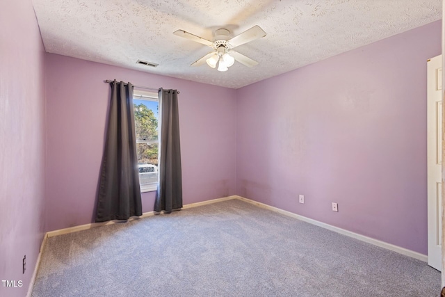 spare room with a ceiling fan, carpet, visible vents, and baseboards