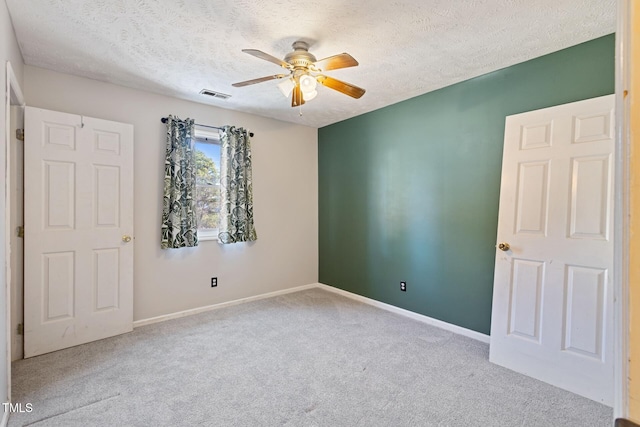 unfurnished bedroom featuring carpet flooring, baseboards, visible vents, and a textured ceiling