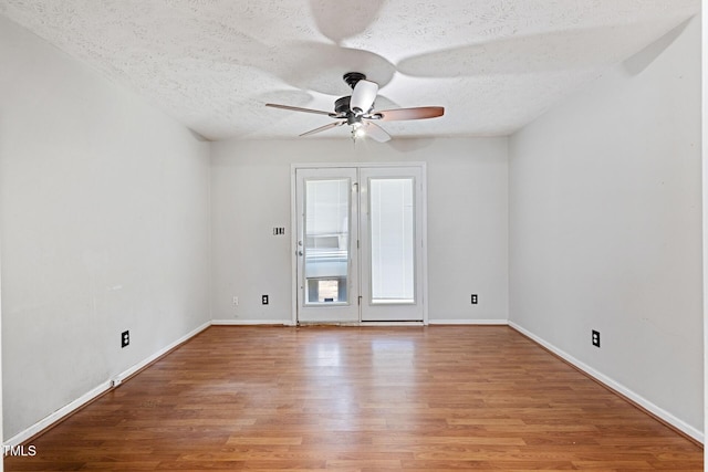 spare room featuring baseboards, a textured ceiling, ceiling fan, and wood finished floors