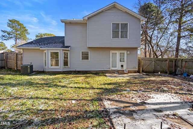 back of property with a lawn, central AC unit, a fenced backyard, and entry steps