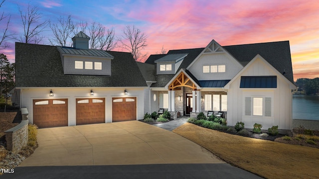 modern farmhouse style home with a standing seam roof, concrete driveway, a garage, board and batten siding, and metal roof