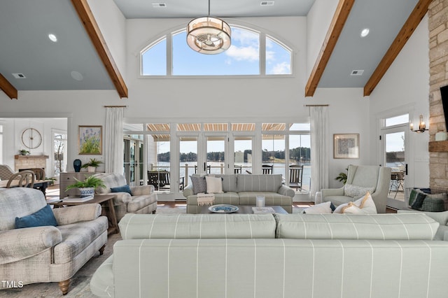 living room with beam ceiling, a fireplace, high vaulted ceiling, and a wealth of natural light