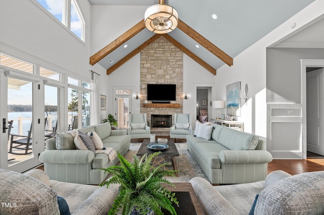 living area featuring a fireplace, beam ceiling, wood finished floors, and high vaulted ceiling