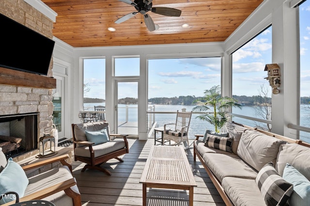 sunroom / solarium with plenty of natural light, wood ceiling, a ceiling fan, and a water view