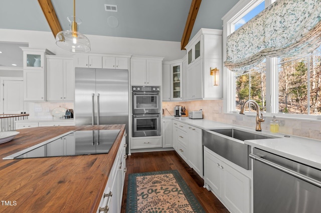 kitchen featuring visible vents, dark wood-style flooring, a sink, appliances with stainless steel finishes, and butcher block counters