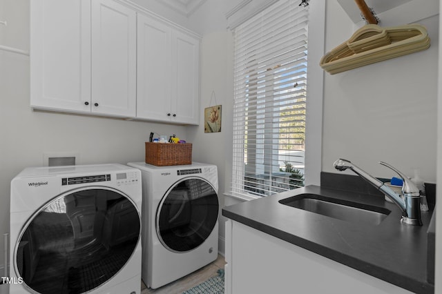 laundry area featuring a sink, cabinet space, and washing machine and dryer