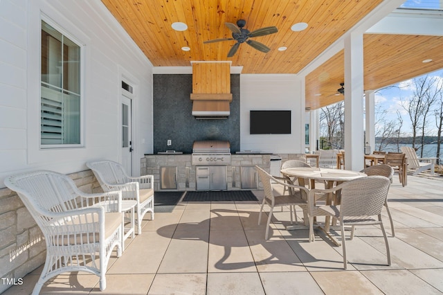 view of patio / terrace with exterior kitchen, outdoor dining area, a ceiling fan, and grilling area