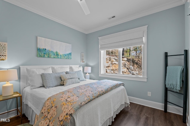 bedroom featuring visible vents, wood finished floors, crown molding, baseboards, and ceiling fan