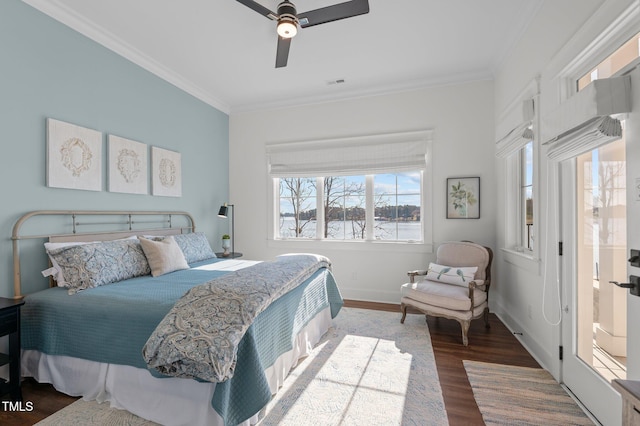 bedroom featuring a ceiling fan, visible vents, wood finished floors, baseboards, and ornamental molding