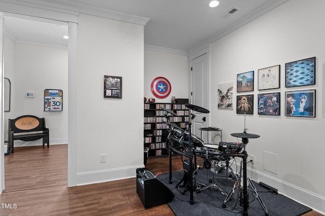 workout room featuring wood finished floors, visible vents, baseboards, recessed lighting, and crown molding