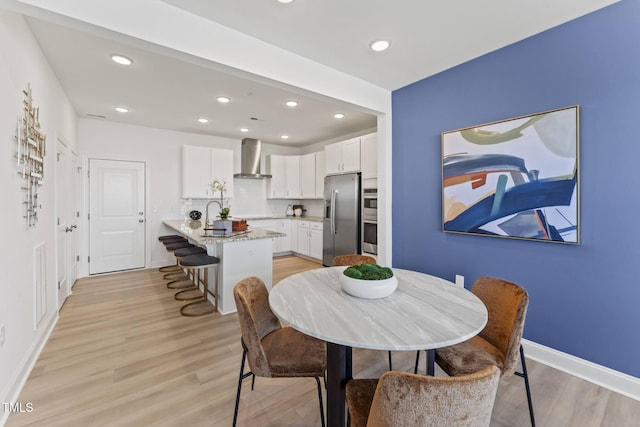 dining space with recessed lighting, baseboards, and light wood-style flooring