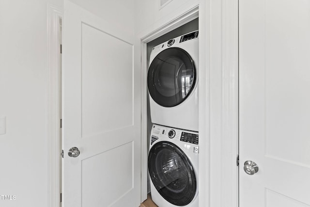 clothes washing area with laundry area and stacked washing maching and dryer