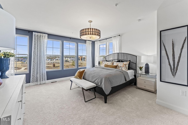 bedroom with baseboards and light carpet