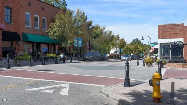 view of street with curbs, street lights, traffic signs, and sidewalks