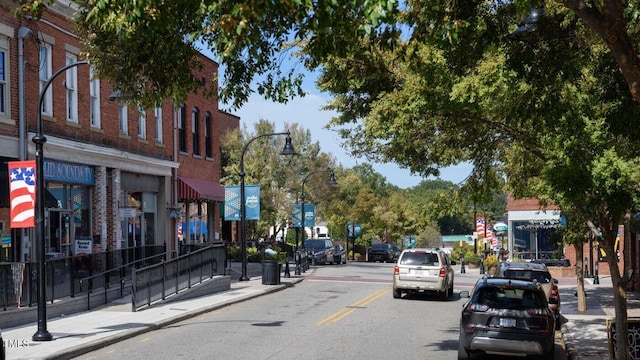 view of street with sidewalks, curbs, and street lighting