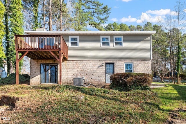 rear view of house with a wooden deck, central AC, a chimney, a lawn, and brick siding