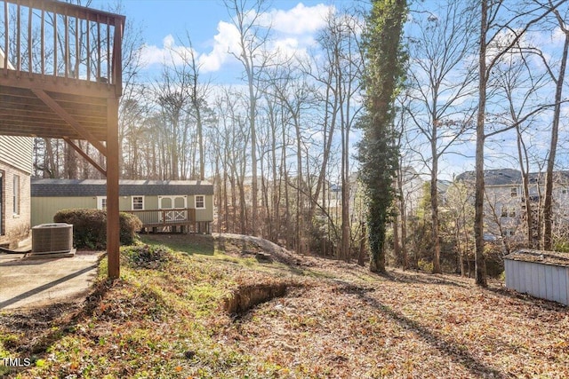 view of yard with central AC unit and a wooden deck