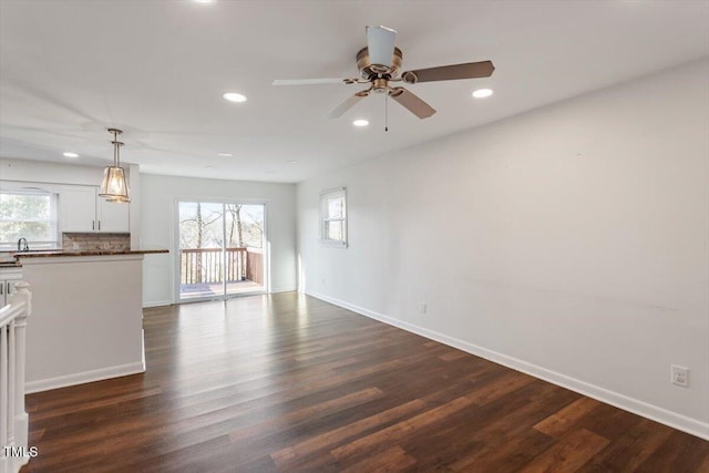 unfurnished living room featuring recessed lighting, dark wood-type flooring, and baseboards