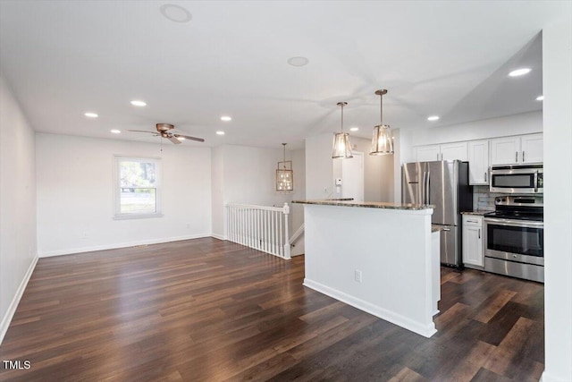 kitchen with decorative backsplash, white cabinets, dark wood-style floors, and appliances with stainless steel finishes