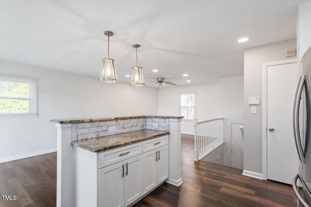 kitchen with stone counters, plenty of natural light, white cabinets, and dark wood-style flooring