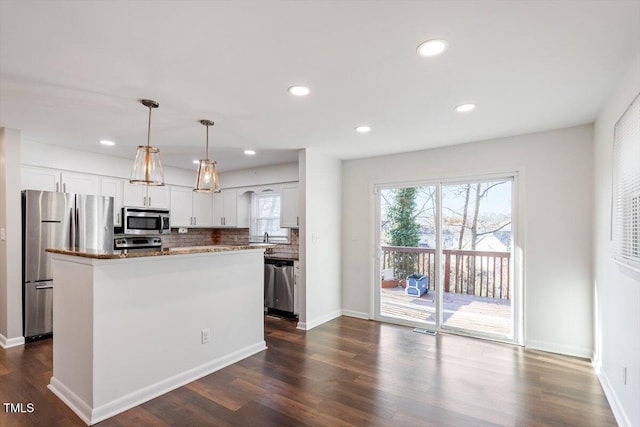 kitchen with decorative backsplash, dark wood-type flooring, white cabinets, and stainless steel appliances