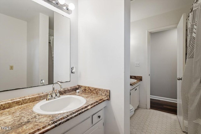 bathroom featuring tile patterned flooring, toilet, and vanity