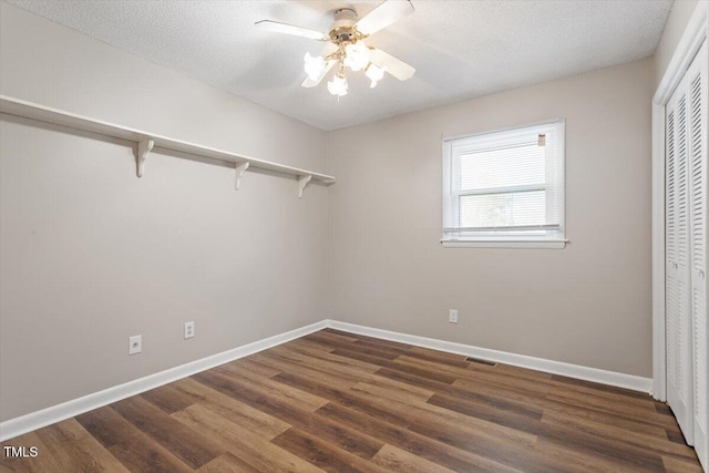 walk in closet with visible vents, a ceiling fan, and wood finished floors