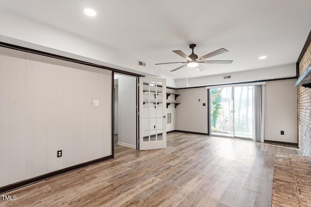 empty room with ceiling fan, visible vents, and wood finished floors