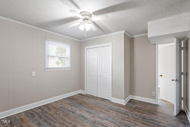 unfurnished bedroom with a closet, ornamental molding, a textured ceiling, and wood finished floors